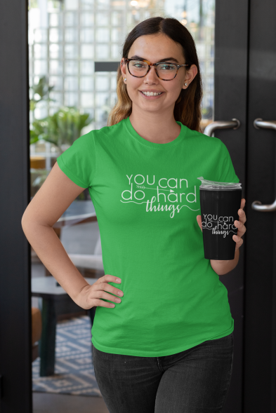 t-shirt-mockup-of-a-woman-holding-a-travel-mug-outside-a-restaurant-29314(1)